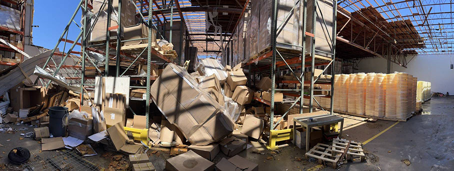 Inside of warehouse with roof ripped off and scattered products